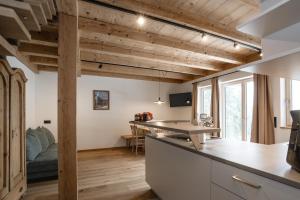 ein Zimmer mit Holzdecke und eine Küche mit einem Tisch in der Unterkunft Weidenchalets in Sellrain