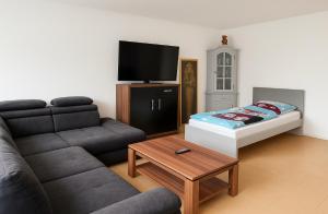 a living room with a couch and a bed at Modernes Stadthaus im Zentrum, 10 Betten 3 Schlafzimmer in Merzig