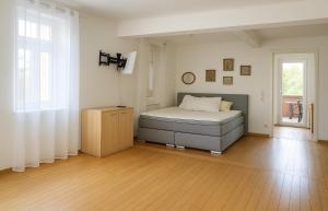 a bedroom with a bed and a wooden floor at Modernes Stadthaus im Zentrum, 10 Betten 3 Schlafzimmer in Merzig