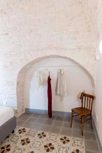 a room with a bed and a dress hanging on a wall at La chiave antica in Alberobello