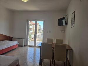 Una habitación con una mesa y sillas y un televisor. en Apartment Zen - Novalja, en Novalja