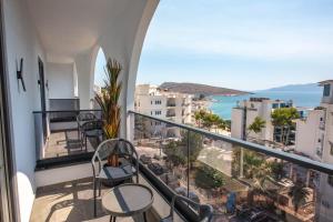 Un balcón con sillas y vista al mar. en Noam Luxury Hotel, en Sarandë