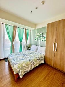 a bedroom with a bed and two windows with curtains at Leisure Escape Azure in Sampong