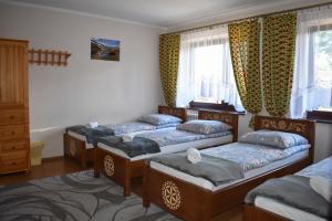 a bedroom with three beds and a window at Pokoje Gościnne u Wioli in Jurgów +64 photos