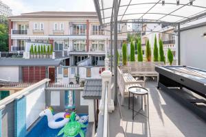 Un balcón con piscina y mesa de billar. en The Terrace Pratumnak 205, en Pattaya South