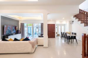 Una sala de estar con un sofá y un comedor. en The Terrace Pratumnak 205, en Pattaya South