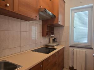 Una cocina con armarios de madera y un fregadero y una ventana. en Apartment Zen - Novalja, en Novalja 10 fotos más