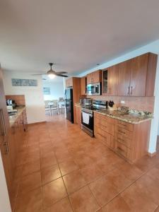 a large kitchen with wooden cabinets and a tile floor at The Yellow House: Fully Equipped, Spectacular Beach View in Manati