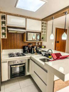 una cucina con fornelli e lavello di Cobertura duplex luxuosa na Praia de Guarajuba, seu Pet é bem vindo a Camassari