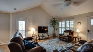 a living room with leather furniture and a flat screen tv at Year-Round Pool & Backyard Near Tybee Island in Savannah