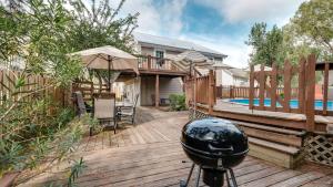 a wooden deck with a pool and a house at Year-Round Pool & Backyard Near Tybee Island in Savannah