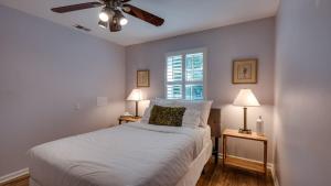 a bedroom with a white bed with a ceiling fan at Year-Round Pool & Backyard Near Tybee Island in Savannah +39 photos