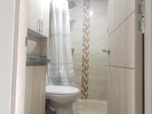 a bathroom with a toilet and a shower curtain at Beautiful Cozy House - Hermosa Casa Acogedora in Ibagué +20 photos