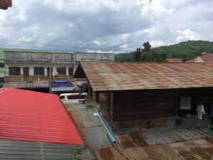 un viejo edificio con un techo oxidado en una ciudad en Oudomphone Guesthouse 2, en Ban Houayxay