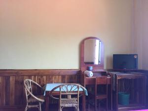 una stanza con tavolo, sedie e specchio di Oudomphone Guesthouse 2 a Ban Houayxay