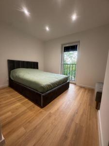 a bedroom with a bed and a large window at Apartament Maksa in Ostróda