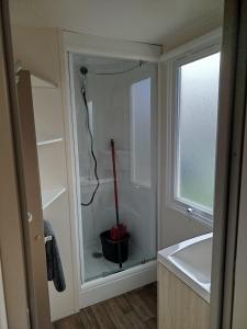 ein Badezimmer mit einem Glasschrank mit Staubsauger in der Unterkunft Mobil home dans camping 3 étoiles in Saint-Papoul