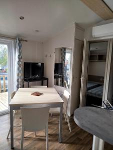 eine Küche und ein Esszimmer mit Tisch und Stühlen in der Unterkunft Mobil home dans camping 3 étoiles in Saint-Papoul