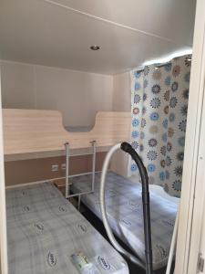 ein kleines Zimmer mit einem Etagenbett und einem Tisch in der Unterkunft Mobil home dans camping 3 étoiles in Saint-Papoul + 2 Fotos