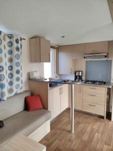 eine kleine Küche mit einem Sofa und einem Tisch in der Unterkunft Mobil home dans camping 3 étoiles in Saint-Papoul