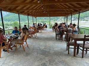 a group of people sitting at tables in a restaurant at Bujtina Brahim Selimaj in Valbonë