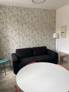 un soggiorno con un divano e un tavolo di Les Halles d'Isa et Thomas a Narbonne