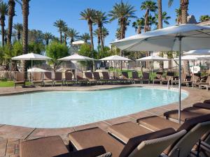 a swimming pool with chairs and an umbrella at The Westin Mission Hills 2BR Apartment with Resort Access in Rancho Mirage +12 photos