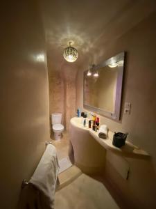 a bathroom with a sink and a mirror and a toilet at Riad Dar Hania en Exclusivité in Marrakech +23 photos