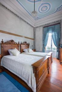 a bedroom with a large wooden bed with white sheets at Quinta da Capela in Viana do Castelo +46 photos