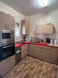 a kitchen with wooden cabinets and red counter tops at Casa Sylvia in Algeciras