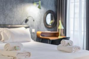 a hotel room with a bed with towels on it at Huguerie 3 Suite Bordeaux Centre in Bordeaux