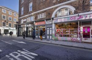 ヨークにあるThe Kings Apt 3 In The Heart Of York - Central Locationの店が並ぶ通りを歩いている数人の人々