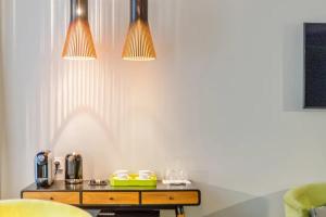 a table in a room with two lights on the wall at Huguerie 3 Suite Bordeaux Centre in Bordeaux