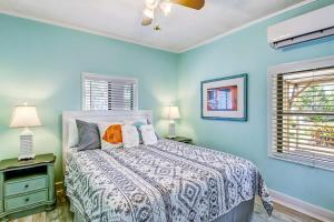 a blue bedroom with a bed and two windows at Beach Vacation! Walkable to Dining&Shopping-Unit A in Tybee Island