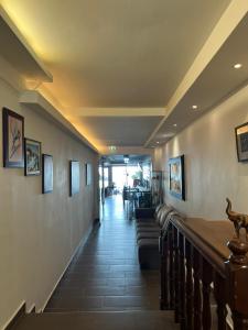a hallway with couches and paintings on the walls at Dafni Seaside Hotel in Leptokarya