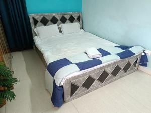プネにある1BHK Service Apartment 201のベッド(青と白のシーツ、枕付)