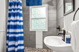 a bathroom with a sink and a shower curtain at Spacious 3 Bedroom on Arbutus Lake in Traverse City +25 photos