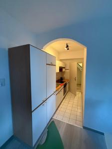 a kitchen with a white refrigerator and a hallway at Neumarkt City Monteurwohnung in Neumarkt in der Oberpfalz
