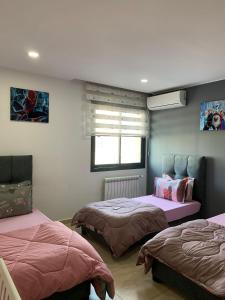 奥兰Appartement lux vue sur mer的有两张床和一扇窗户的卧室