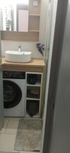 a bathroom with a sink and a washing machine at la brise marine in Plage dʼArgelès +6 photos