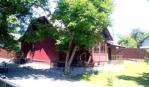 a red building with a tree in front of it at Mover mount apart in Skole