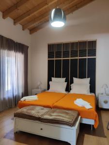 una camera da letto con un letto grande con una coperta arancione di Pátio do Forno a Mértola