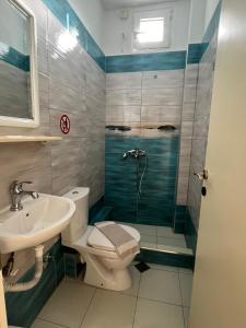 a bathroom with a shower and a toilet and a sink at Dafni Seaside Hotel in Leptokarya +40 photos