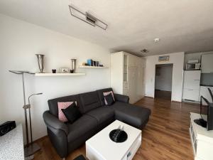 a living room with a black couch and a table at Panorama Whg 42, 2 OG in Cuxhaven