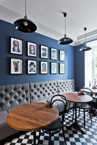 un restaurant avec deux tables et des chaises et des murs bleus dans l'établissement 15th Avenue, à Vilnius