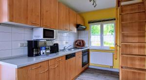 a kitchen with wooden cabinets and a counter top at Ferienhütte Ilmtalblick in Ilmenau