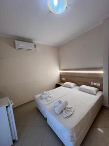 a hotel room with a bed with towels on it at Dafni Seaside Hotel in Leptokarya