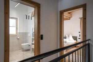 ein Badezimmer mit einer Glastür, die zu einem Schlafzimmer führt in der Unterkunft Weidenchalets in Sellrain + 57 Fotos