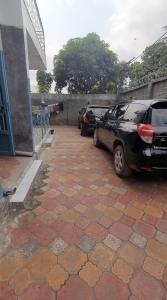 two cars parked in a parking lot next to a building at Appartement Amani in Kinshasa