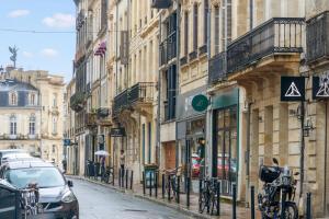 Una calle de la ciudad con coches aparcados en la calle. en Huguerie 2 Suite Bordeaux Centre Climatisation, en Burdeos